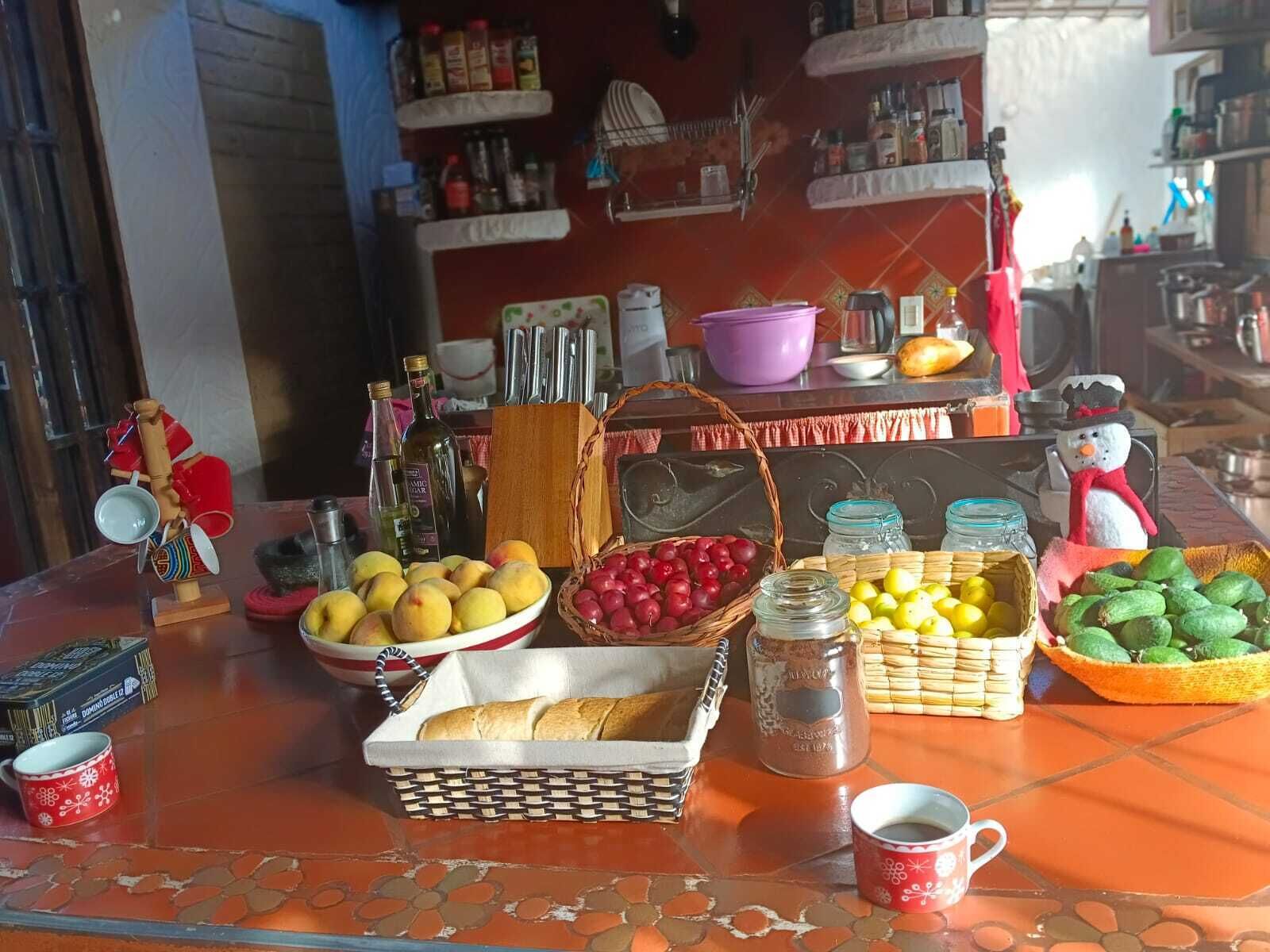 A kitchen counter with various food items, including fruits, bread, and condiments.