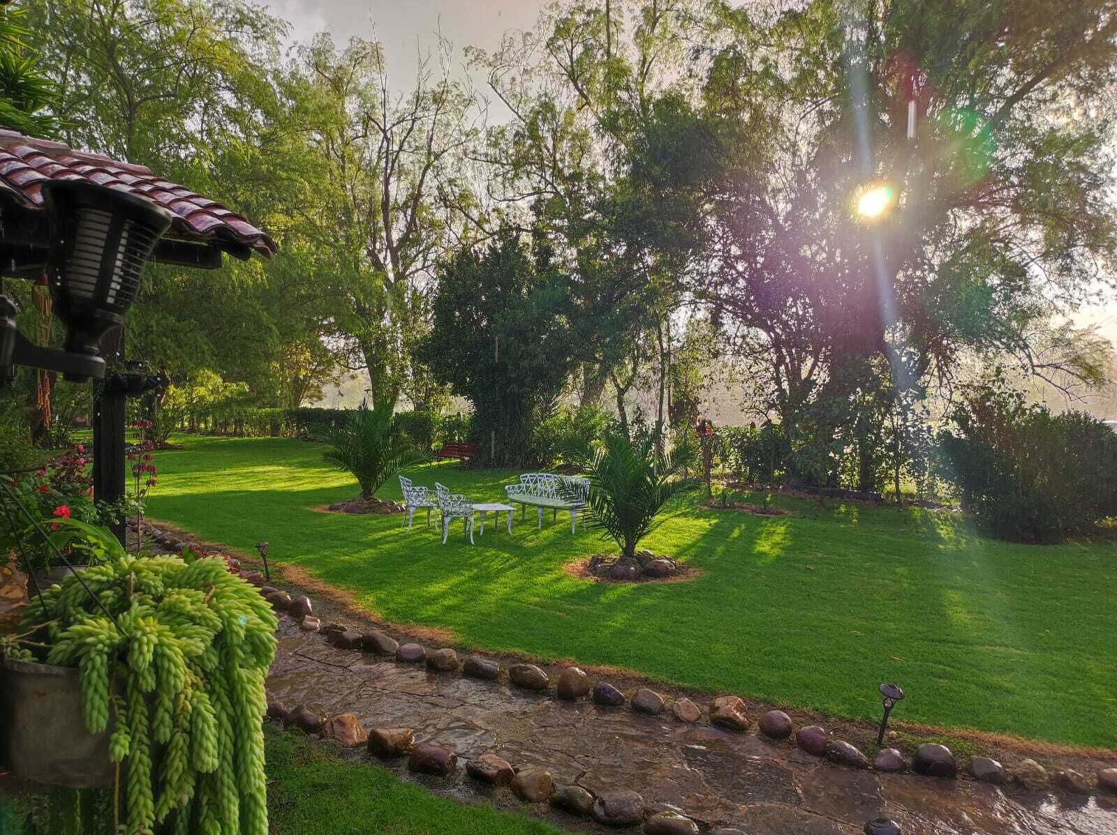 A well-maintained garden with a patio area, stone pathway, and a small water feature.