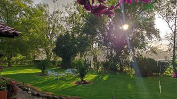 A well-maintained garden with a lawn, seating area, and a small water feature.