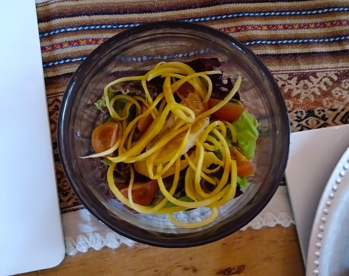 Un tazón de ensalada de pasta con verduras sobre una mesa.