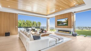 A modern living room with a large sofa, a fireplace, and a TV.
