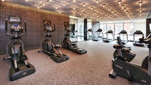 A gym with treadmills, ellipticals, and stationary bikes arranged in rows. - Studio 2BR Apt with GYM, Close to CN Tower (Toronto)