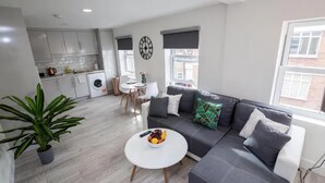 Eine moderne Wohnung mit Wohnbereich, Küche und Essbereich.