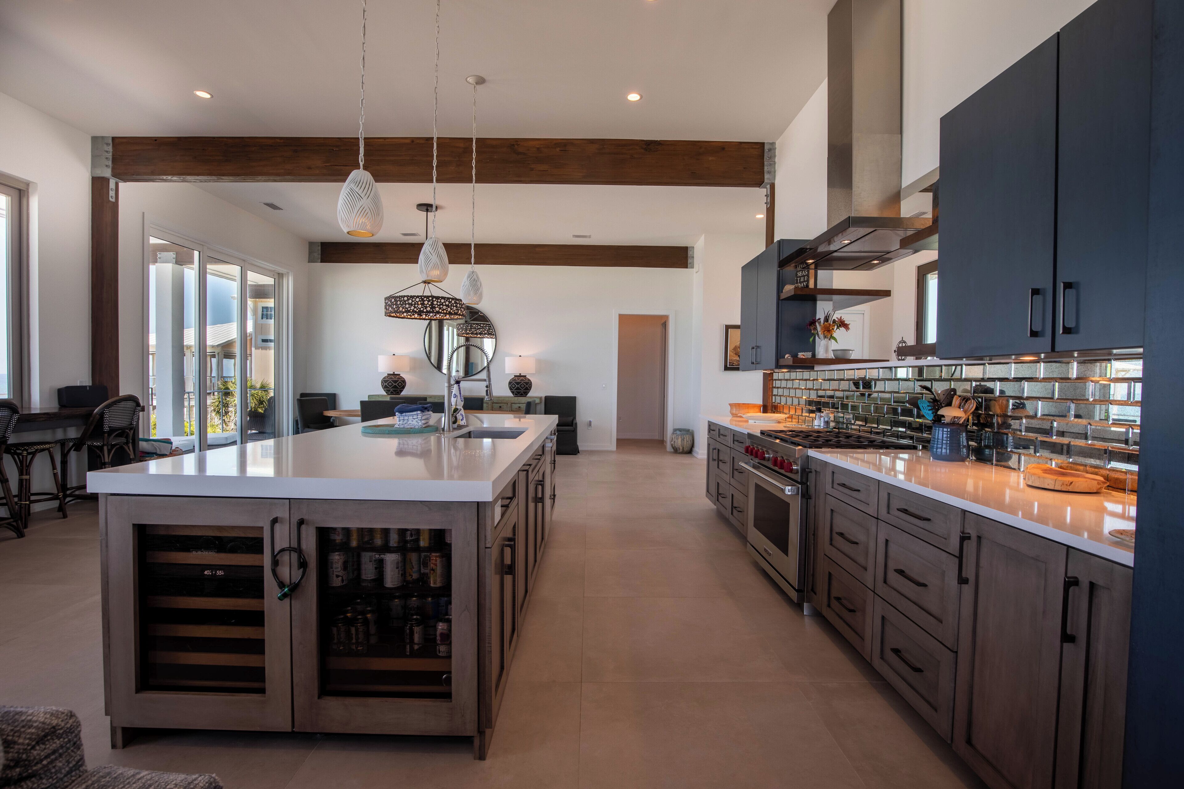 A spacious kitchen with a large island, dark cabinetry, and modern pendant lighting.