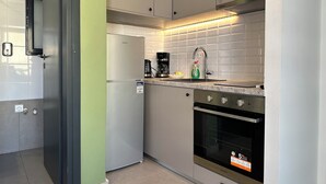 Een moderne keuken met een inbouwkoelkast, een koffiezetapparaat en een spoelbak.