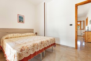 A bedroom with a bed, a wooden headboard, a small bedside table, and a mirror. - 3922 Villino Gioiellino by Barbarhouse (Melendugno)