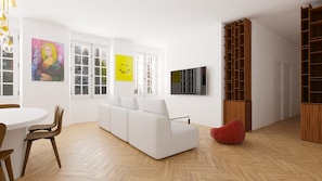 A modern living room with a white sofa, a red bean bag, a dining table with chairs, a TV, and a bookshelf.
