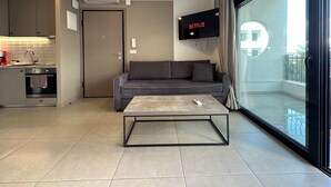 Un salon moderne avec un canapé gris, une table basse et un téléviseur affichant le logo « NETFLIX ».