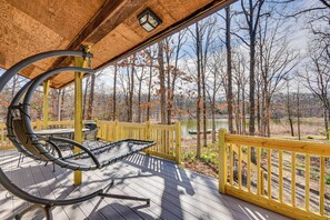 A wooden deck with a hammock and a table, overlooking a lake and trees. - Historic Clark Cabin w/ Deck & Fishing Pond Access (Clark)