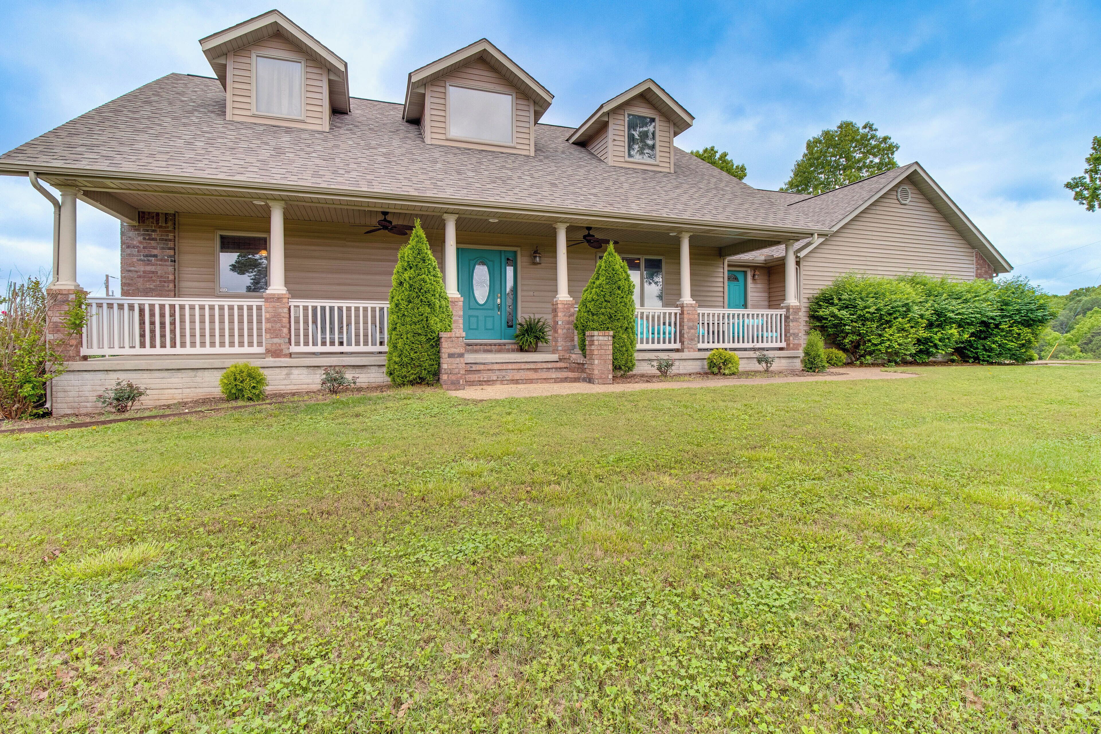 A two-story house with a front porch, a covered entryway, and a well-maintained lawn.