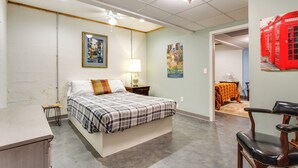 A bedroom with a bed, a chair, a nightstand, a lamp, and a wall-mounted telephone. - Jasper Apartment w/ Patio & Creek Access (Jasper)