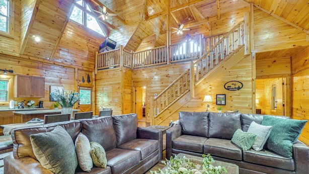 Un intérieur de cabine spacieux, avec un revêtement en bois, un escalier, des canapés en cuir et un coin repas.