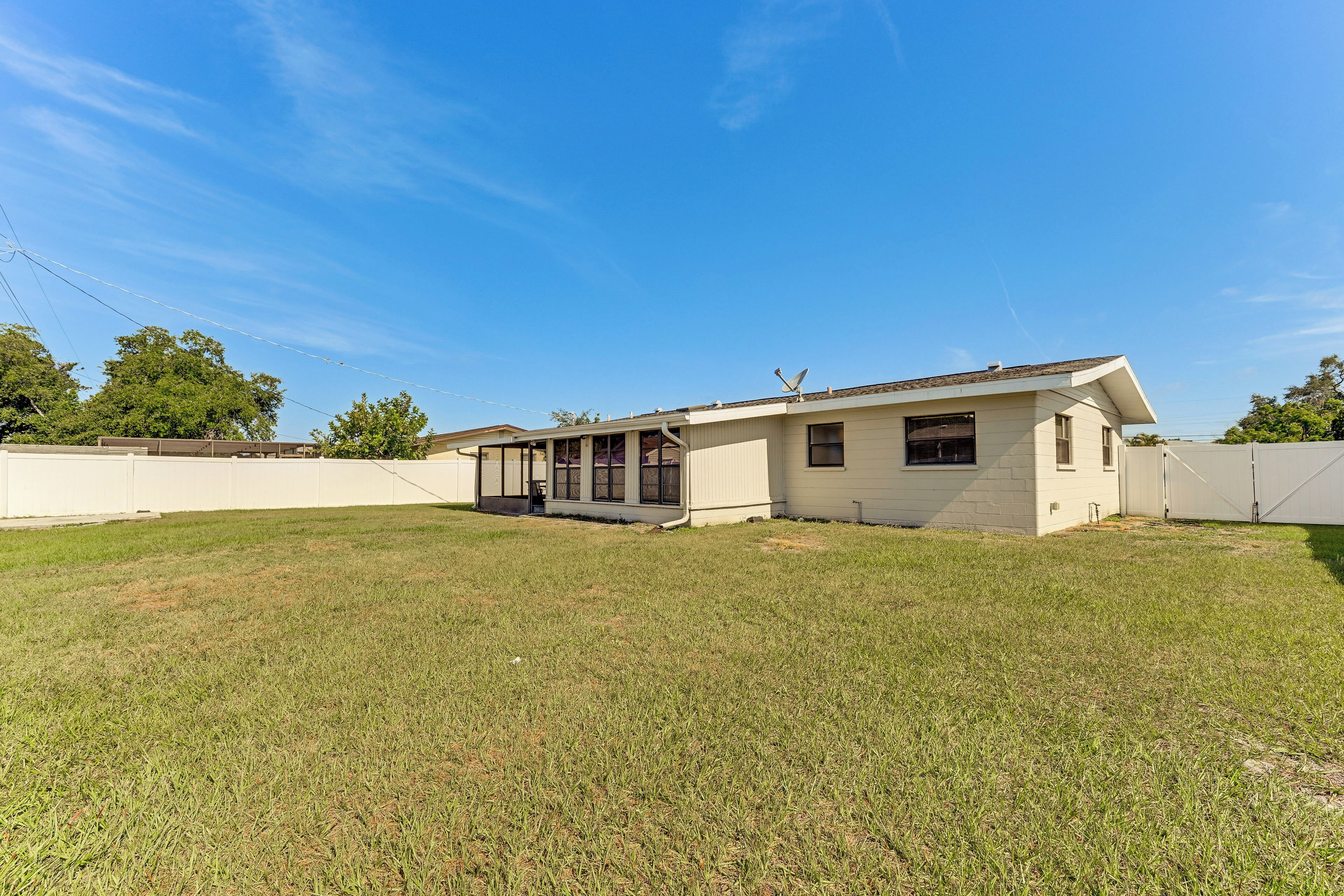 A single-story house with a front porch, a garage, and a fenced backyard.
