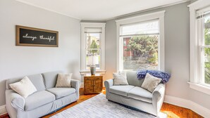 Ein Wohnzimmer mit zwei grauen Sofas, einem Holztisch und einem Teppich.