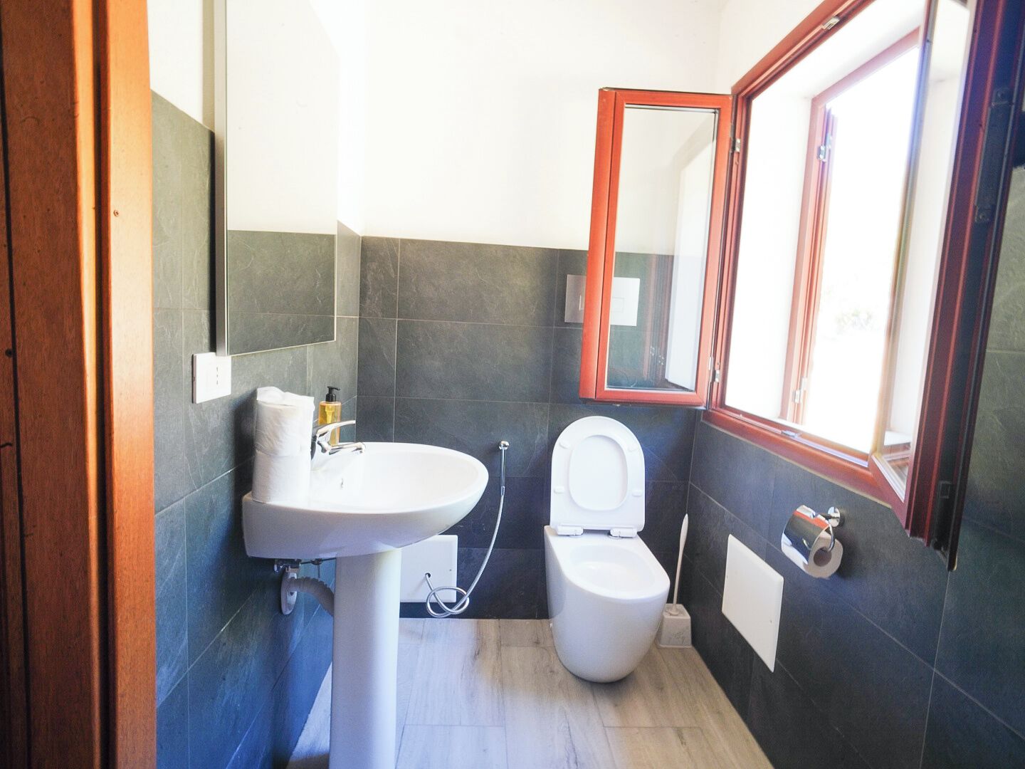 A bathroom with a white sink, a toilet, and a mirror.