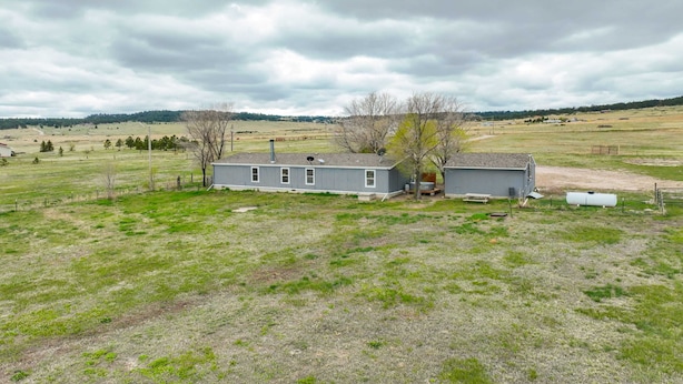 A single-story house with a fenced yard, a satellite dish, and a small shed.