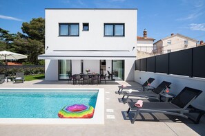 A modern two-story house with a swimming pool, outdoor seating, and a covered patio area. - Villa Rudina in Pomer (Pomer)