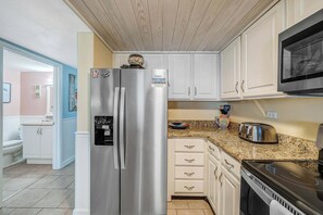 A kitchen with a stainless steel refrigerator, a microwave, and a toaster.