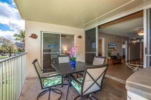 A balcony with a dining table, chairs, and a potted plant. - Royal Mauian, #307 2 Bedroom Condo by RedAwning (Kihei)
