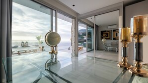 A modern interior with a glass table, a globe, and elegant candle holders. - Luxury Villa Pérola (Calheta)