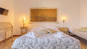Ein Hotelzimmer mit einem großen Bett, zwei Nachttischen, einem Schreibtisch und einem Bild an der Wand.