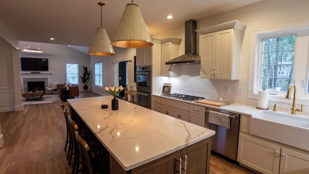 A spacious kitchen with a large island, modern appliances, and ample natural light. - New Home in Marion Village! (Marion)