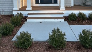 A two-story house with a dark front door, white columns, and a porch with steps leading to the entrance. - New Home in Marion Village! (Marion)