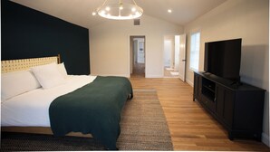 A bedroom with a bed, a television, and a hallway leading to another room. - New Home in Marion Village! (Marion)