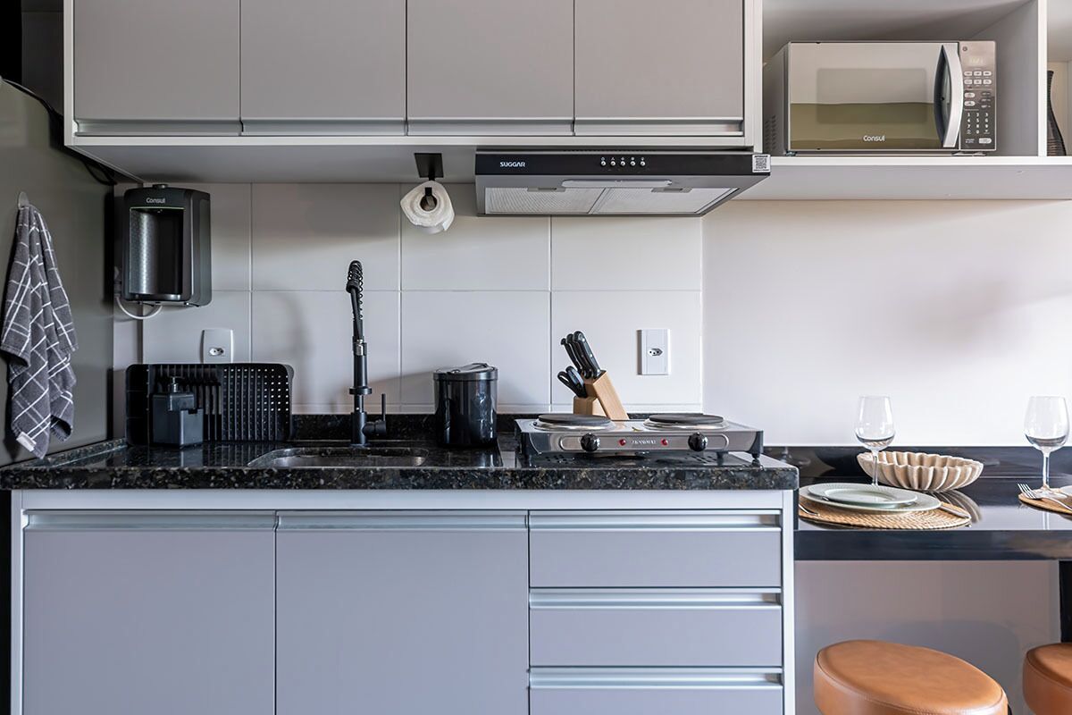 A modern kitchen with a microwave, stove, and various utensils.