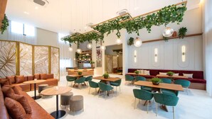Un intérieur moderne comprenant un espace salon, des tables et un bar.