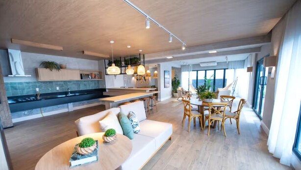 Une cuisine moderne avec un coin repas, un canapé et une table agrémentée de plantes.