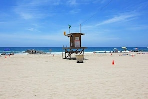 A lifeguard tower on a beach with clear skies.