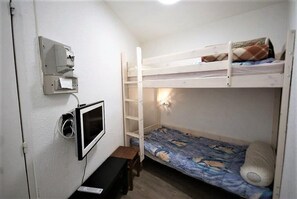 A bunk bed room with a desk, a wall-mounted TV, and a power outlet. - 100m from resort center, 9th floor, balcony, parking, tv, ski locker, 32m², Pra Loup (Pra Loup)
