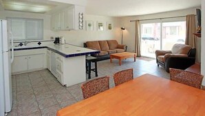 Eine kompakte Küche mit Essbereich, einer Couch und einem Couchtisch.
