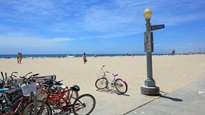 Ein Strand mit abgestellten Fahrrädern in der Nähe eines Straßenschilds.