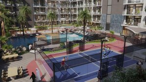 Ein Tennisplatz auf dem Dach, umgeben von einem Schwimmbad und Liegebereichen.