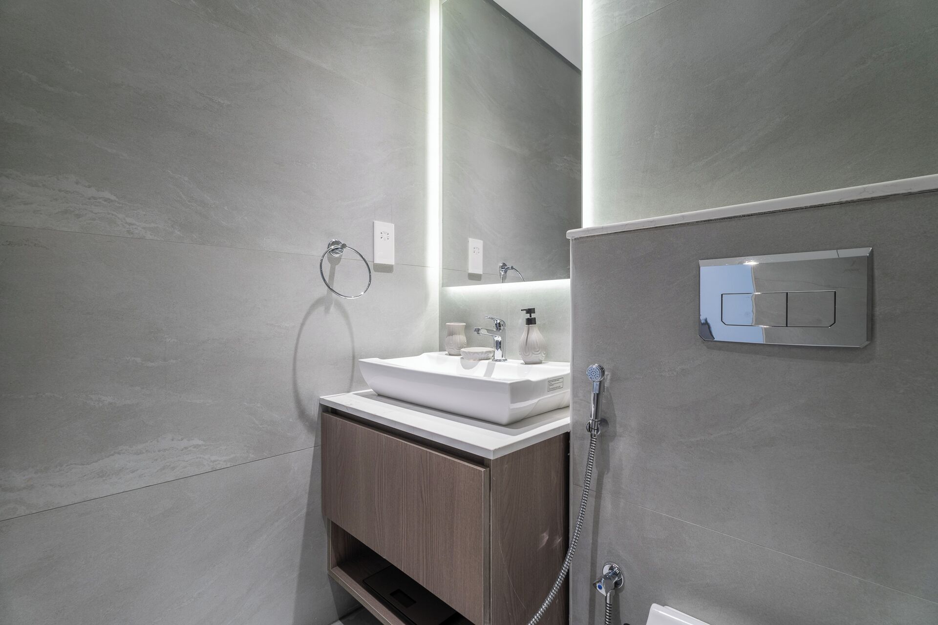 A modern bathroom with a white sink, a mirror, and a shower.