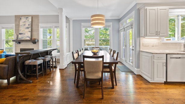 A spacious dining area with a long table, chairs, and a central light fixture. - Spacious 5 Bedroom, Hot Tub, Arcade Room, EV Charger, Handicap & Quiet Culdesac! (Raleigh)
