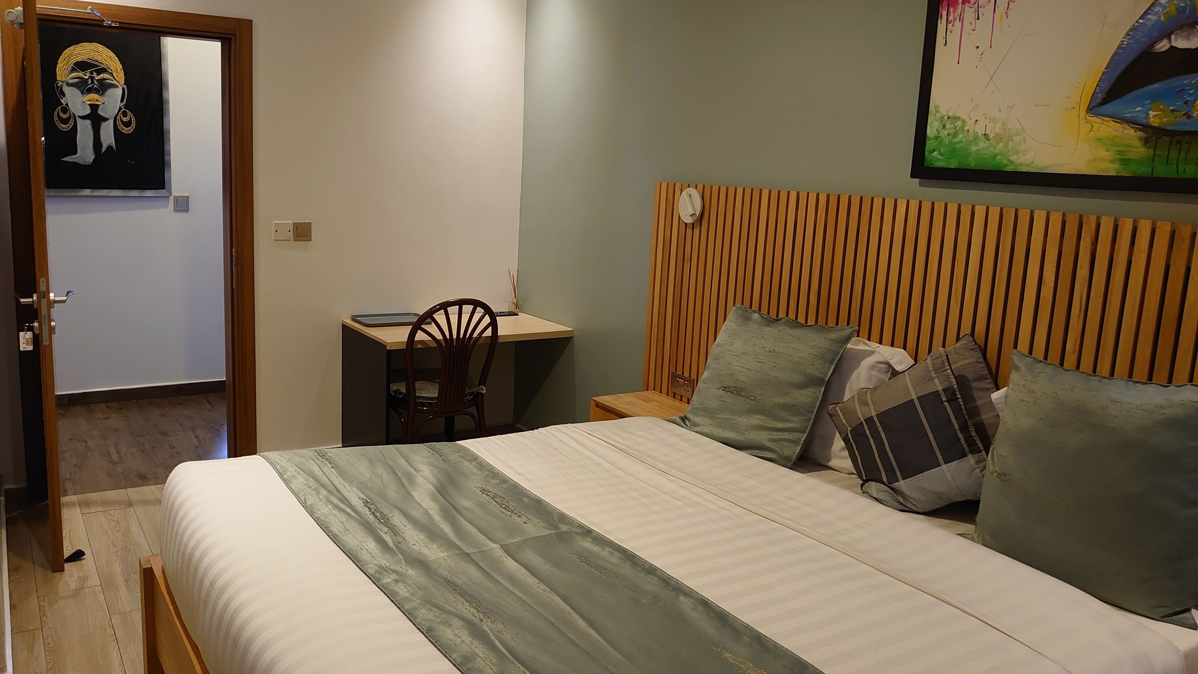 Un dormitorio con cama, escritorio y silla.