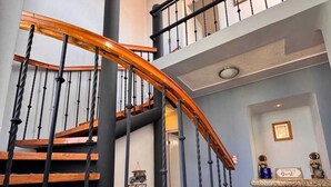 A staircase with wooden steps and black balusters, leading to a second floor.