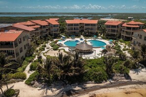 A resort with multiple buildings, a central pool area, and surrounding greenery.