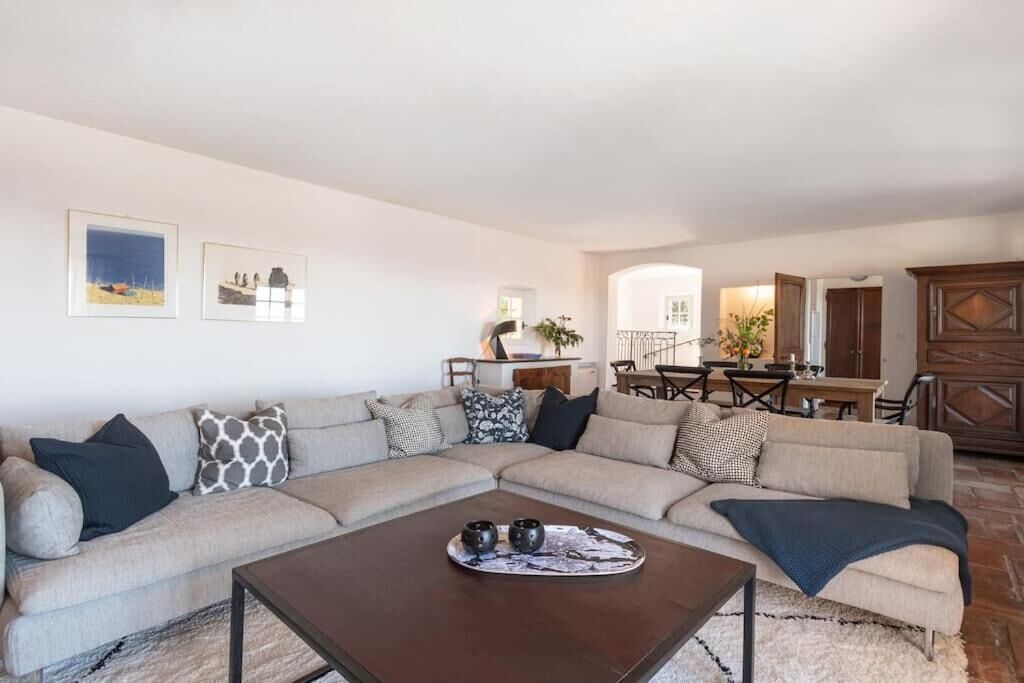 A living room with a beige sectional sofa, a coffee table, and a dining area with a table and chairs.