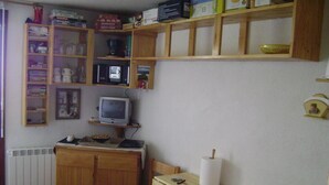 A small room with a wooden desk, a chair, a television, and shelves with various items. - Ski-in/ski-out & foot of the slopes, 2nd floor, balcony, tv, ski locker, 19m², Samoëns (Samoëns)