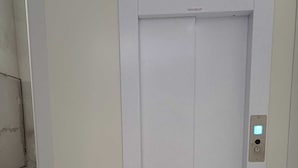 Un ascenseur moderne doté d’un panneau de commande situé sur le côté droit.