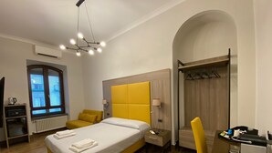 Une chambre d’hôtel moderne équipée d’un grand lit, d’un bureau, d’une chaise et d’une armoire.
