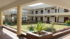 A multi-level atrium with a central courtyard, columns, and potted plants. - Flamingo Tourist Resort (Hisar)