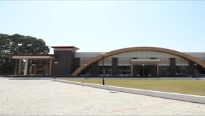 A modern building with a curved entrance, paved area, and a sign indicating 'NEXT'. - Flamingo Tourist Resort (Hisar)