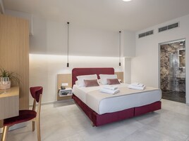Una camera da letto moderna con un letto grande, comodini, una scrivania e una sedia.