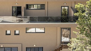 Un edificio de varios pisos con balcones, ventanas amplias y una escalera.