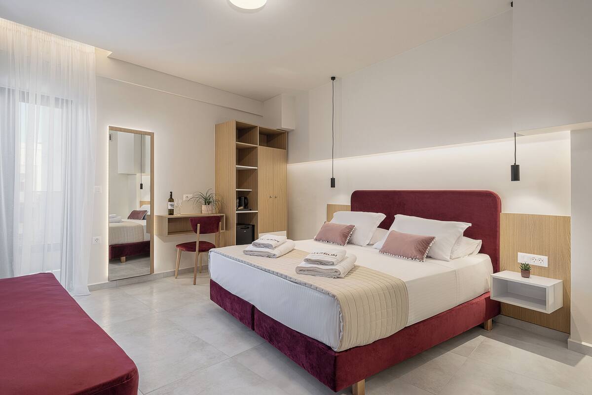 Ein modernes Schlafzimmer mit einem großen Bett, einem Schreibtisch und einem Kleiderschrank.
